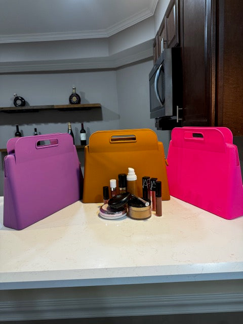 3 LARGE (GRANDE) IBIG SILICOME MAKEUP BAGS IN FUSCHIA PINK,PURPLE AND BROWN.MAKEUP ITEMS ARRANGED IN FRONT OF THE BAGS make up bags / toiletry bags / toiletry / toiletries / make up / make up case /Travel makeup bag / travelbag / travel bags for women / toiletry travel bag / travelbags / cosmetic bags/beauty bag/ makeup / makeup organizer